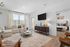 Bright living room with a cozy sofa, stylish decor, and a glimpse into a modern bedroom.