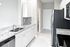 Modern kitchen with sleek marble countertops, stainless steel appliances, and elegant white cabinetry offering a luxurious cooking space.