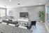 Bright and modern living room with sleek gray accents, elegant furniture, and a large window offering natural light.