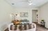Cozy living room with stylish decor, featuring a plush tan armchair, modern artwork, and elegant lighting, perfect for relaxation.