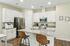 Modern kitchen with sleek granite countertops, stainless steel appliances, and a cozy breakfast bar with stylish wooden stools.