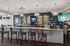 Chic and inviting bar area featuring elegant lighting, a sleek countertop, and a well-stocked selection of beverages.