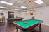 Luxurious recreation room with two classic billiard tables, warm lighting, and elegant wooden furniture, perfect for entertainment.