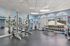 Spacious, well-lit gym with modern workout equipment and scenic outdoor views, ideal for fitness enthusiasts seeking comfort and productivity.
