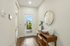 Bright and inviting entryway featuring a modern wooden console table, elegant decor, and a stylish round mirror, offering a welcoming glimpse into a beautiful home.