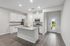 Modern kitchen with sleek granite countertops, white cabinetry, and stainless steel appliances, accented by elegant hardwood flooring and natural light from adjacent doorway.