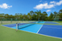 Inviting tennis courts with vibrant blue and green surfaces surrounded by lush trees and clear skies.