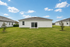Charming suburban home with a spacious green backyard and sliding glass doors, perfect for outdoor activities and entertaining.