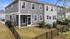 Charming townhouse with modern grey siding, private fenced yard, and cozy screened porch in a peaceful neighborhood.