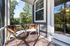 Inviting outdoor patio with cozy seating, stylish cushions, and lush greenery in the background.