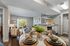 Charming open-concept apartment with elegant dining setup, inviting living room, and modern kitchen overlooking a lush garden patio.