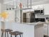 Modern kitchen with sleek granite countertops, stainless steel appliances, and stylish bar seating, highlighted by elegant decor elements.