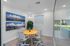Modern dining area with vibrant decor, featuring a round wooden table and stylish chairs, accented by large scenic wall art.