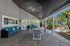 Elegant outdoor patio with modern ceiling fans, stylish blue seating area, and tropical garden views, perfect for relaxation and social gatherings.