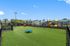 Vibrant apartment playground featuring colorful slides, lush green lawns, and spacious play areas.