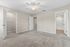 Bright and spacious bedroom with plush carpeting, ceiling fan, walk-in closet, and convenient en-suite bathroom access.