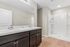 Elegant bathroom featuring a twin-sink vanity with a marble countertop and a spacious walk-in shower.