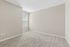 Bright and spacious bedroom with plush carpeting and large window for ample natural light.