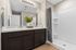 Elegant bathroom with dual sinks, modern mirror lighting, and a sleek walk-in shower.