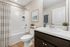 Bright and modern bathroom featuring sleek white fixtures, elegant marble countertop, and tasteful decor for a serene ambiance.