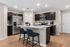 Modern kitchen with sleek stainless steel appliances, elegant dark cabinetry, and an inviting island with seating, ideal for cooking and entertaining.