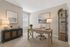 Inviting home office with elegant decor, featuring a sleek wooden desk, cozy chair, and modern shelving, bathed in natural light.