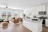 Bright and modern open concept living area with stylish kitchen, cozy seating, and abundant natural light.