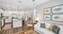 Bright and inviting open-concept kitchen and living area with modern decor, featuring white cabinets, stainless steel appliances, and chic artwork, perfect for comfortable living.