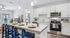 Contemporary open-concept kitchen and living area with high-end appliances, elegant island seating, and stylish decor, perfect for entertaining in comfort and style.