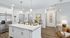Bright and inviting kitchen area with modern white cabinetry, sleek stainless steel appliances, and a stylish island counter perfect for casual dining.