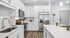 Bright and modern kitchen with sleek white cabinetry, stainless steel appliances, and a spacious island, perfect for entertaining.