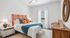 Bright and inviting bedroom with a stylish orange headboard, cozy bedding, and chic decor accents.