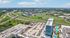 Breathtaking aerial view of a luxury apartment complex featuring lush greenery, scenic highways, and two sparkling pools, offering an unparalleled living experience.