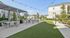 Charming outdoor communal area featuring pergolas with seating, lush greenery, and modern apartment buildings in the background, perfect for relaxation and social gatherings.