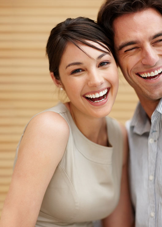 Happy couple leaned close to each other and their heads are touching near their temples.
